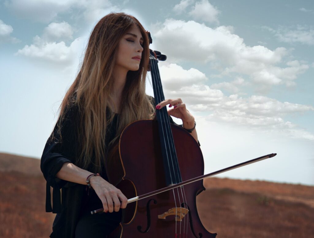 lady playing the cello in a seed field